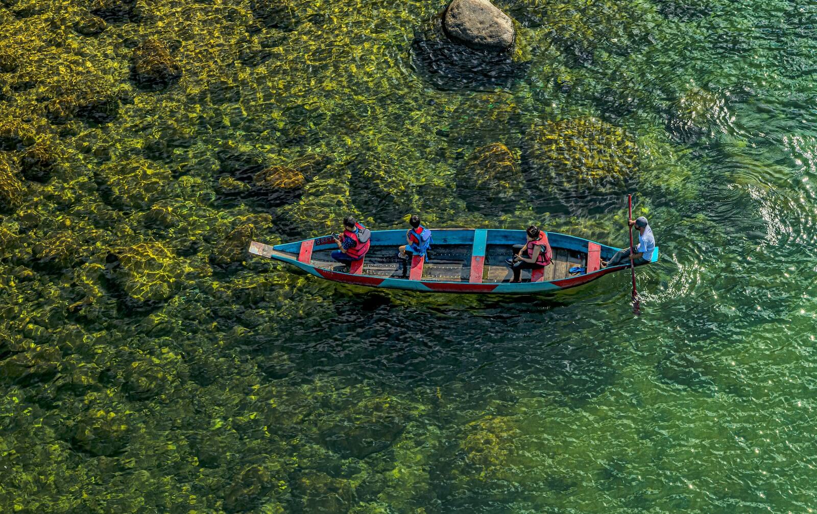 A boat with people floating on clear water